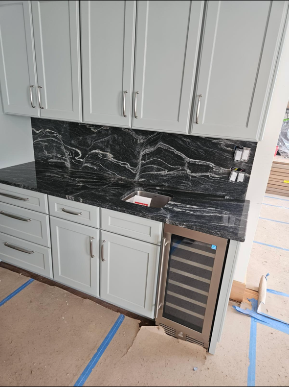 Kitchen island with granite countertop and cabinetry by Ray Builders